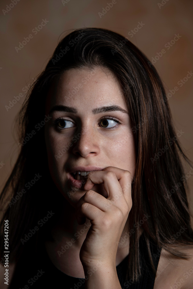 Young girl with fear expression biting fingernails portrait Young girl with fear expression biting fingernails portrait