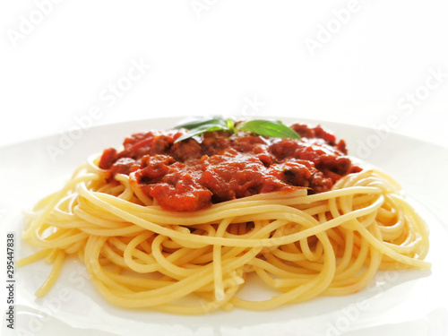 Spaghetti Bolognese with minced beef, onion, chopped tomato, garlic, olive oil, stock cube, tomato puree and Italian herb. Traditional Italian food in a white plate on white background.