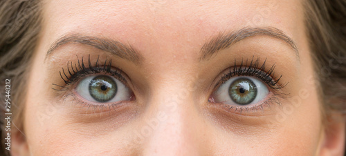 Woman face with green eyes shocked expression close up photo