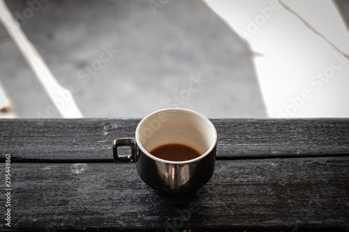 Coffee cup on a black wood table, outside