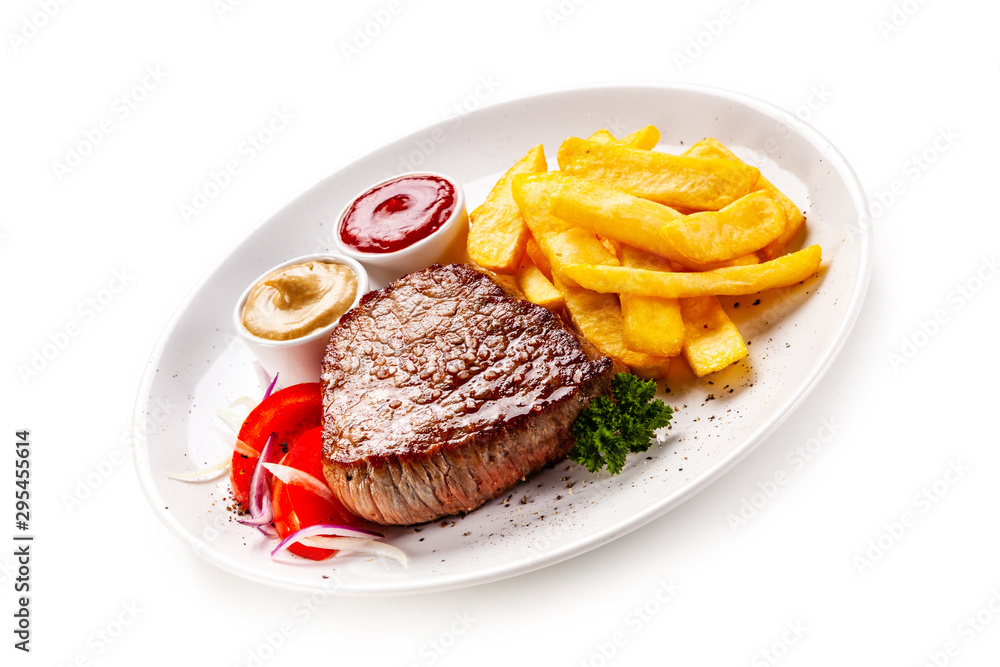 Grilled steaks, French fries and vegetables