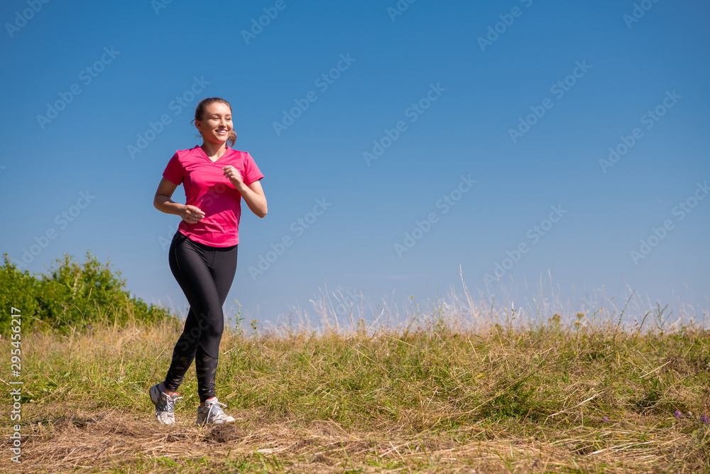 young woman jogging on sunny day at summer mountain young woman jogging on sunny day at summer mountain