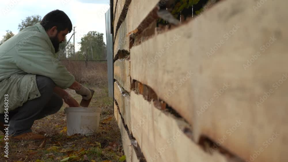 Bearded man paints a new wooden fence. Processing a new wooden fence. Painting a new fence. Bearded man paints a new wooden fence. Processing a new wooden fence. Painting a new fence.