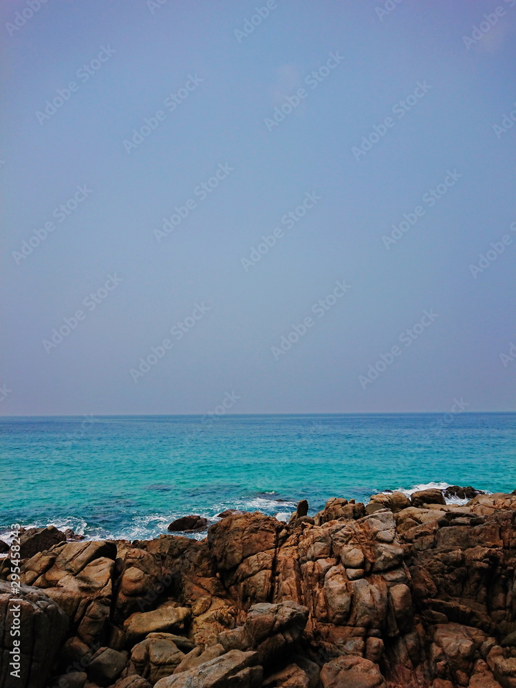 Rock beach rim an Andamun Sea  Blue water and Blue sky 