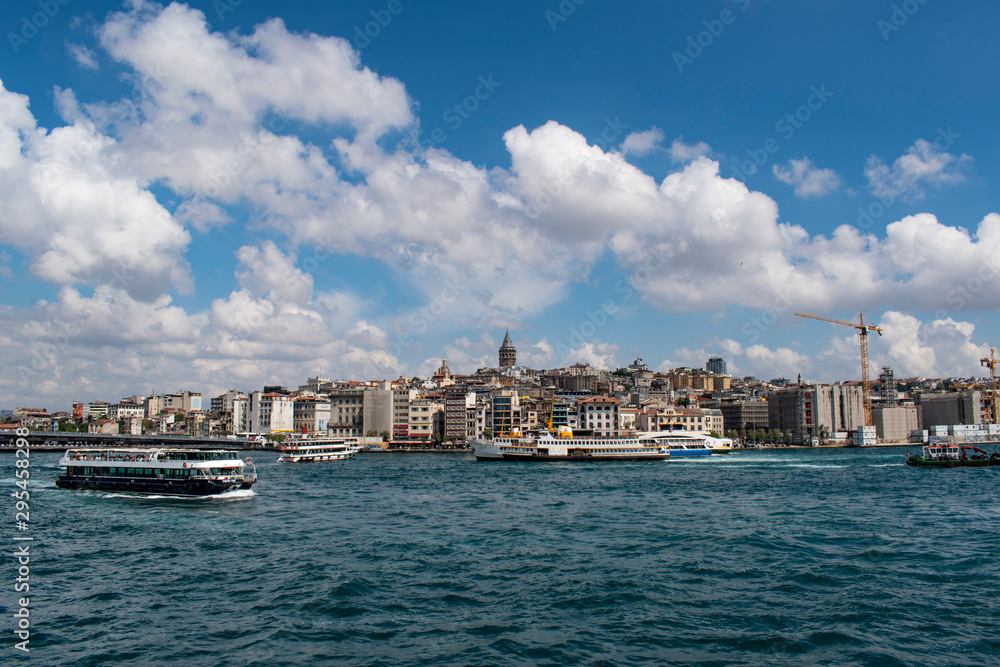 Istanbul, Turkey: the breathtaking skyline with the Galata Tower and a ship crossing the Bosphorus for a cruise in the Strait of Istanbul, part of the continental boundary between Europe and Asia
