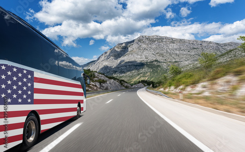 A bus with the flag of the United States of America rushes along the highway. Trip to usa - concept.