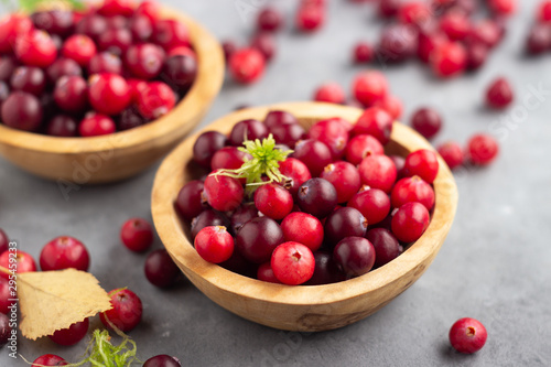 Fresh red cranberry in wooden bowl. Autumn harvest of wild berries. photo