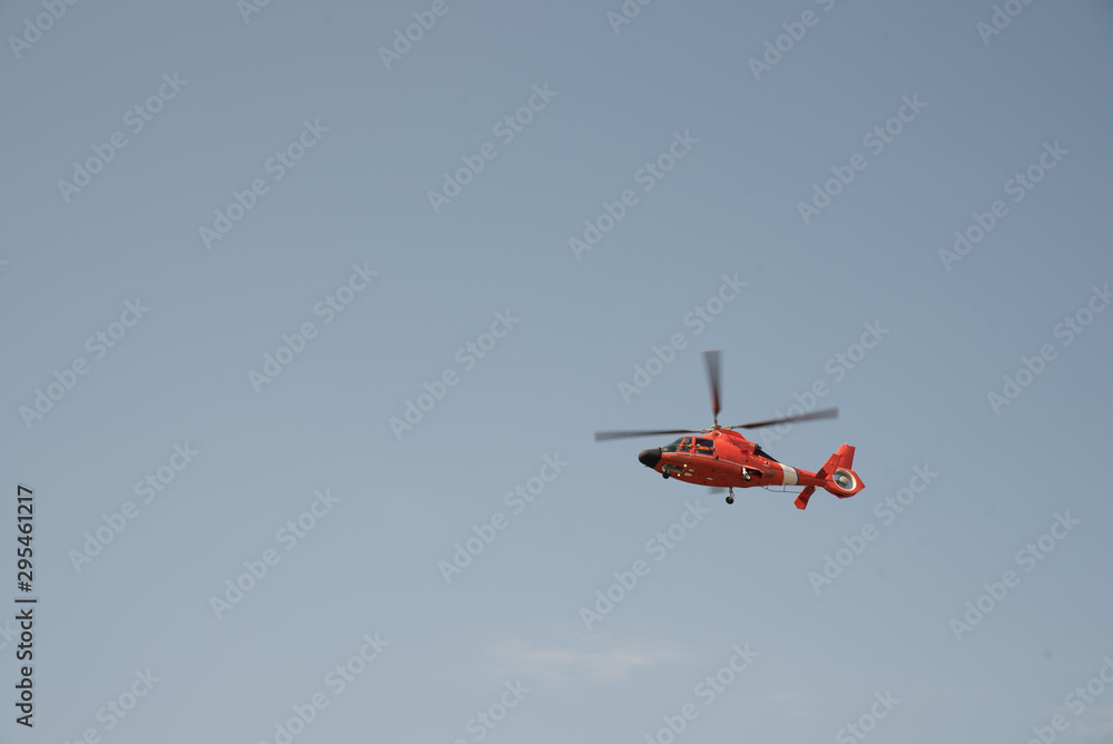 Orange helicopter flying in a cloudless sky Orange helicopter flying in a cloudless sky