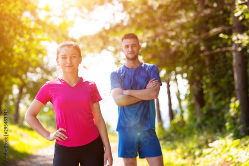 portrait of young couple jogging on sunny day at nature