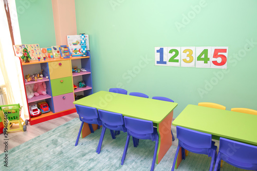 Kids . Children's playroom with plastic colorful educational blocks toys . Shelf with many colored toys . Children sit at tables in the garden . Baby's room with shelves with toys . © Adil