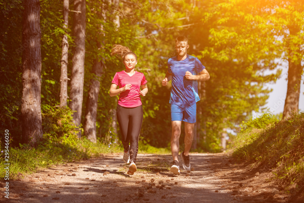 Fototapeta premium young couple jogging on sunny day at nature