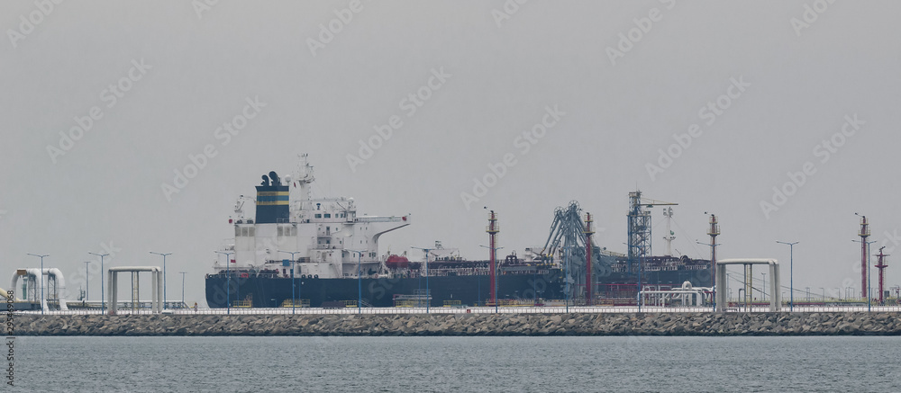 Obraz premium OIL TERMINAL - Big tanker and seaport fuel waterfront infrastructure