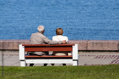 senior couple sitting on bench and look at the water