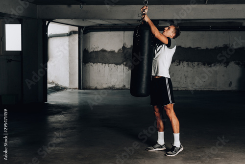 Muscular man prepare for workout on punching bag
