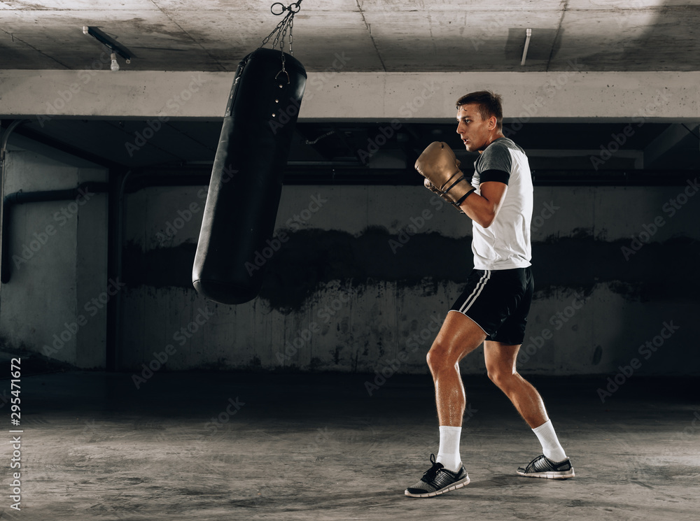 Horizontal view of handsome sporty man training boxing