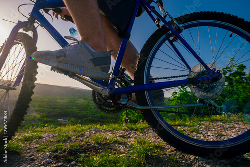 Close up photo from a mountain biker riding his bike ( bicycle) on rough rocky terrain on top of a mountain, wearing no safety equipment. Adrenalin junkie.