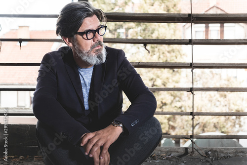 Portrait of mature handsome male model who posing in old abbandoned hall