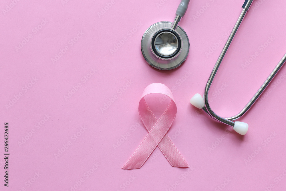 Fototapeta premium Pink ribbon and stethoscope on pink background, Symbol of breast cancer in women, Health care concept