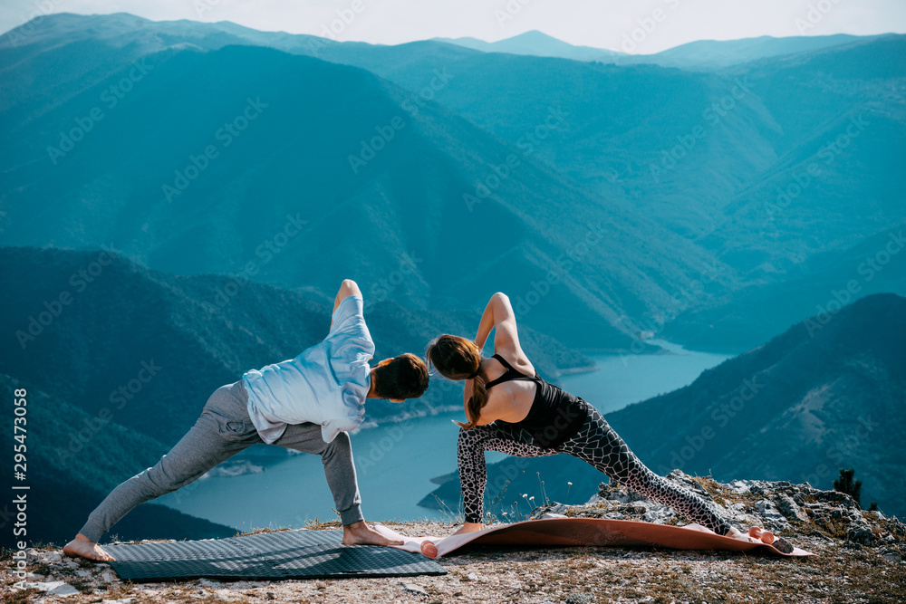 Young couple doing yoga at sunset. Lifestyle Healthy
