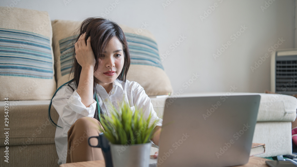Serious woman using laptop and sitting on sofa. Serious woman using laptop and sitting on sofa.