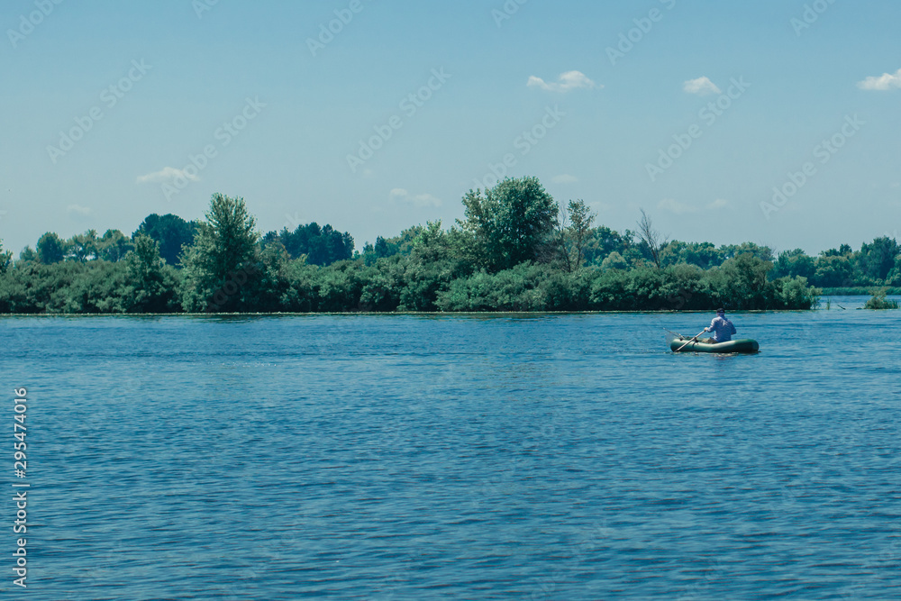 Fisherman on a boat in the middle of the river