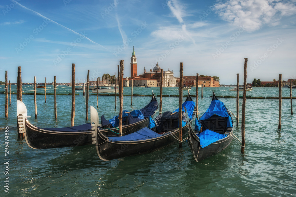 San Giorgio Maggiore Island against blue gondolas in the Bacino San Marco. Venice, Italy.