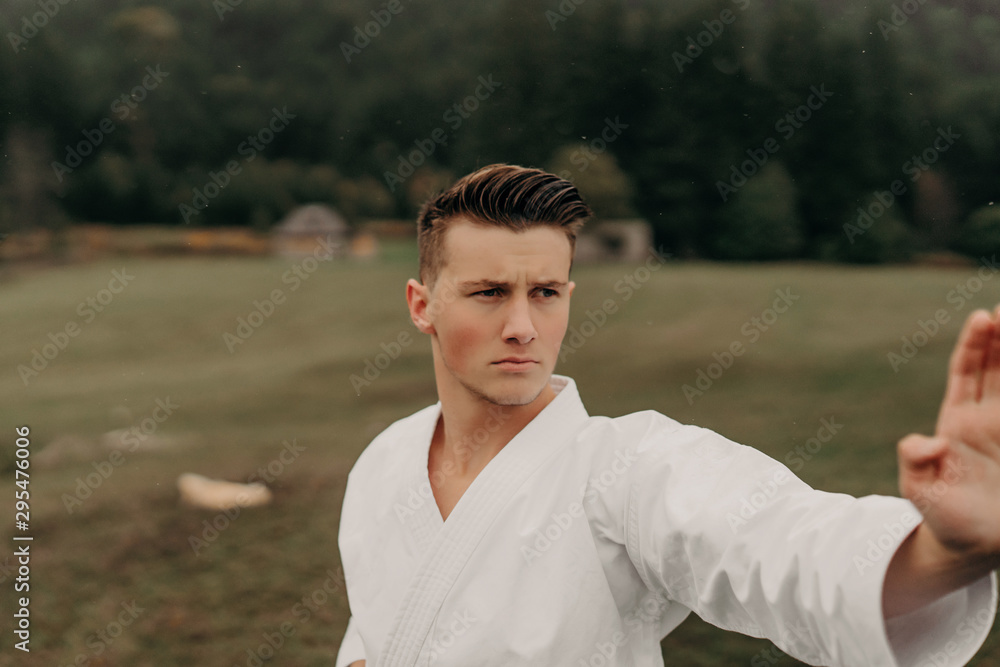 Martial art of karate, a man in a kimono with black belt trains on the mountain,free space. Martial art of karate, a man in a kimono with black belt trains on the mountain,free space.