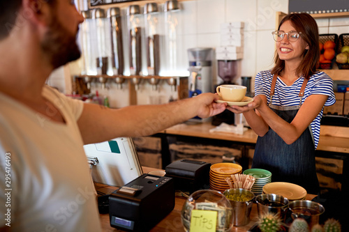 Woman making fresh coffee and serving customer