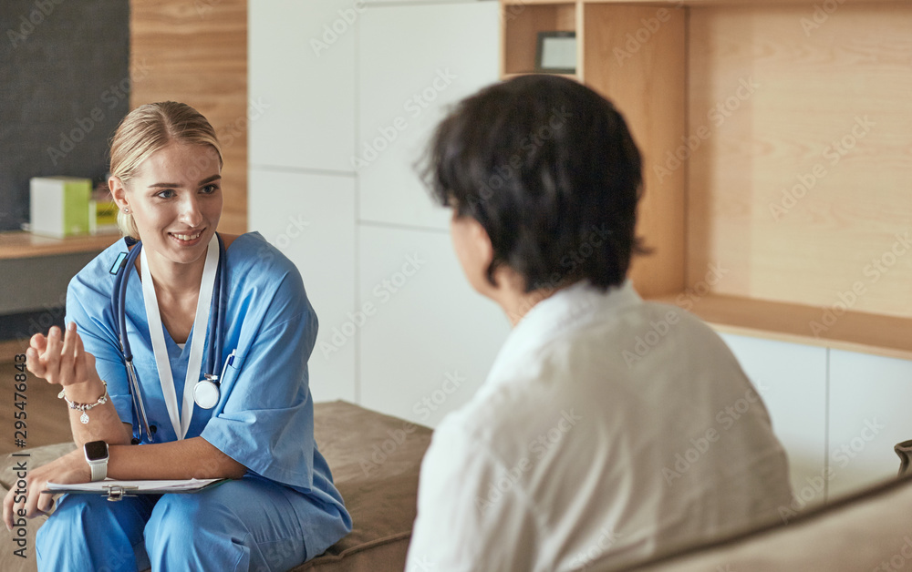 Obraz premium Friendly smiling doctor and patient sitting on the couch. Very