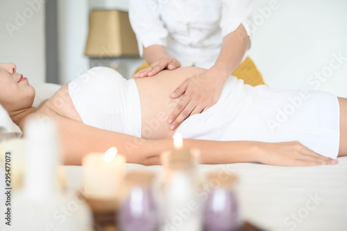 pregnant woman having massage in spa relax , a massage to the belly of a pregnant girl 