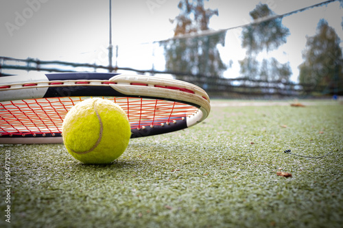 Tennis racket and a ball on grass court