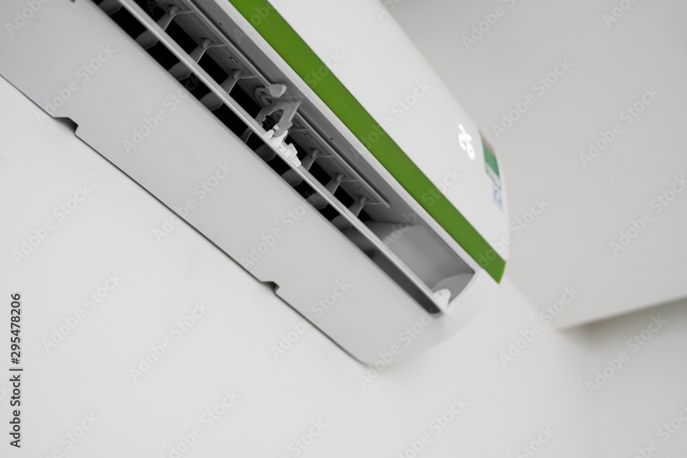 Air conditioner mounted on a white wall in the living room or bedroom. Indooor comfort temperature. Health concepts and energy savings. Air conditioner mounted on a white wall in the living room or bedroom. Indooor comfort temperature. Health concepts and energy savings.