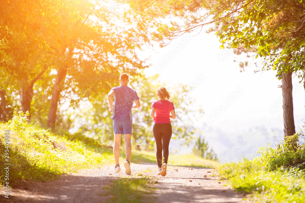 Obraz premium young couple jogging on sunny day at nature