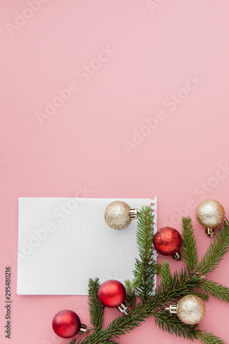 New year concept. Goals list in notepad, gift box and christmas decoration on pink pastel color with copy space