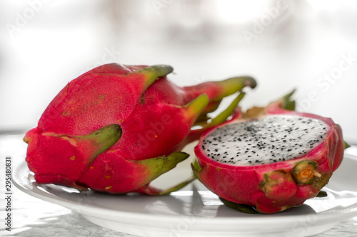 Dragon fruit. Vibrant Dragon Fruit on white background. Sliced white dragon fruit or pitaya on white plate on the table, close-up. Tropical and exotic fruits. Healthy and vitamin food concept.