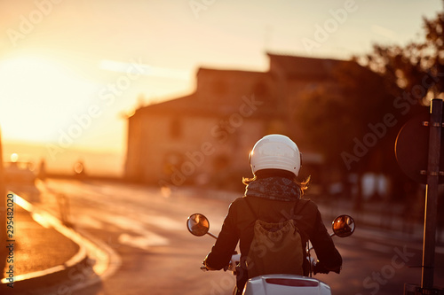 Travels by scooter. girl riding motor scooter on road.