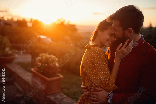 romantic man and woman at sunset. Smiling man and woman is enjoying sunset photo