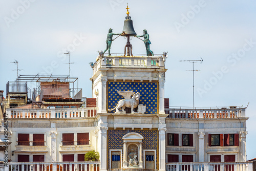 Old Clock tower Torre dell'Orologio on the San Marco square (St Mark), Venice, Italy. It is a landmark of city. Ancient clock with bell outside in the Venice center. Medieval architecture of Venice. photo