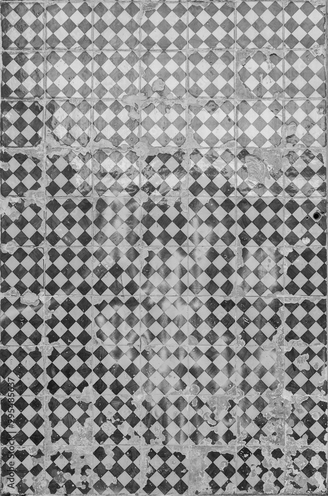 Close-up of an old, weathered and cracked wall with ceramic tiles (azulejos) in Lisbon, Portugal. High resolution full frame textured background in black and white. Close-up of an old, weathered and cracked wall with ceramic tiles (azulejos) in Lisbon, Portugal. High resolution full frame textured background in black and white.
