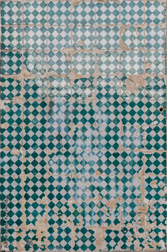 Close-up of an old, weathered and cracked wall with colorful ceramic tiles (azulejos) in Lisbon, Portugal. High resolution full frame textured background.