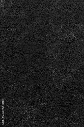 Close-up of a plastered, painted rough wall. Dark high resolution full frame textured background in black and white.