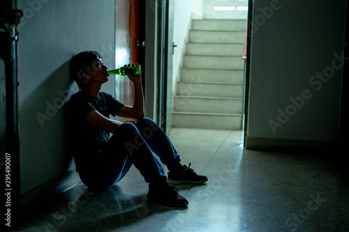 Silhouette of drunk man holding and drinking beer are having stress in life and unable to find a solution and no advisor, from work problems And a failed family life. Alcoholic.