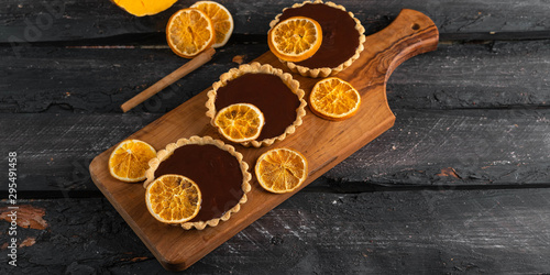 chocolate orange tartlets, dark wooden backdrop, winter dessert concept