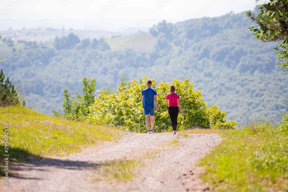 young couple jogging on sunny day at nature