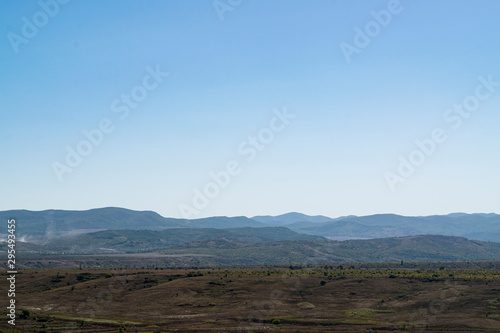Crimean landscape. Steppe in the foreground and mountains covered with fog in the background.