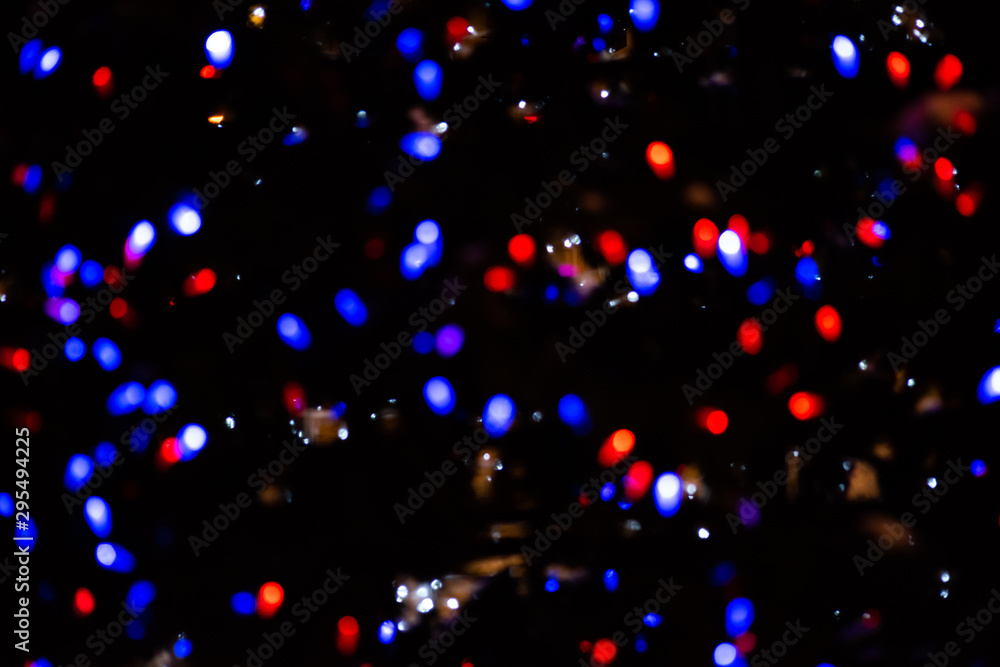 Blurred background with small blue and red bokeh of a festive garland Blurred background with small blue and red bokeh of a festive garland