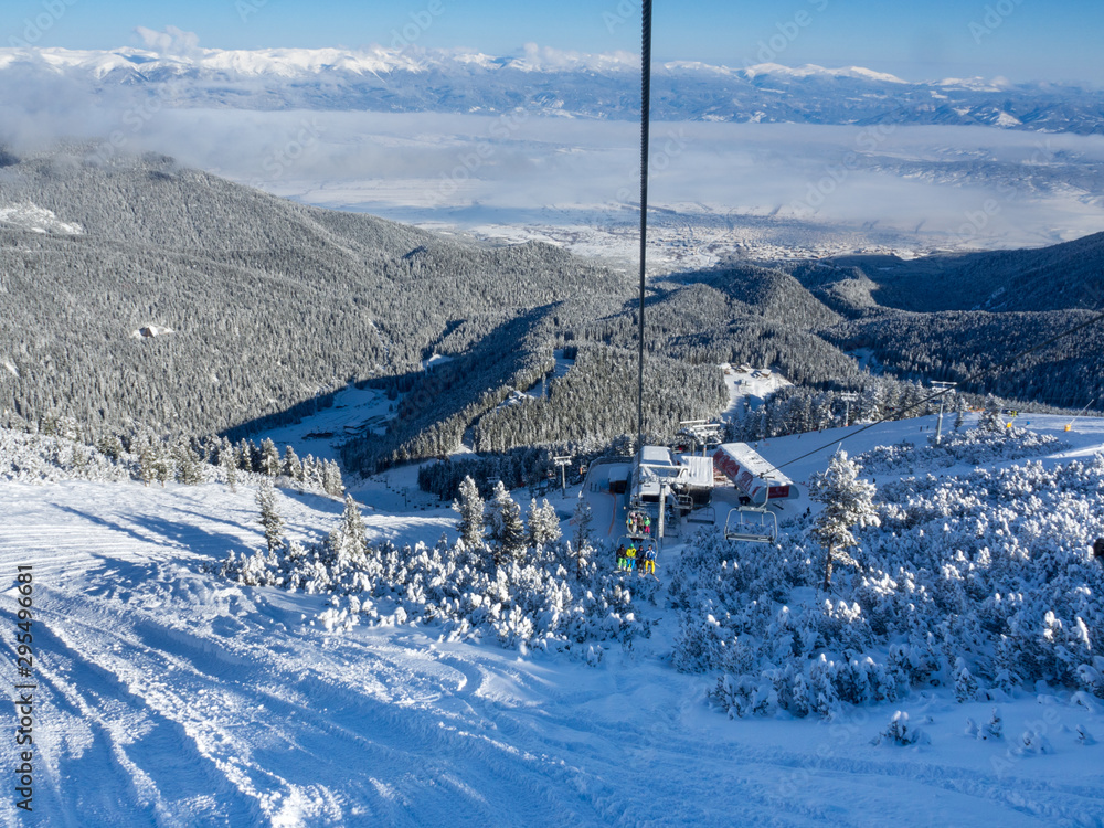 Bansko, Bulgaria - January 2017: Winter ski resort Bansko with ski slope, lift cabins, people and mountains view