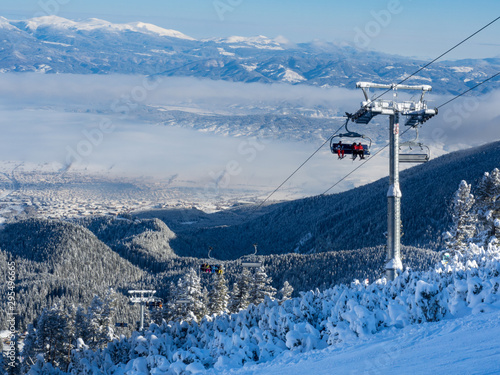 Bansko, Bulgaria - January 2017: Winter ski resort Bansko with ski slope, lift cabins, people and mountains view