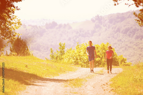 young couple jogging on sunny day at nature