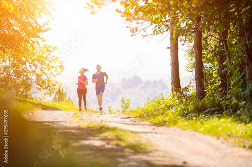 young couple jogging on sunny day at nature